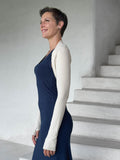 caraucci-woman-wearing-cream-sleeve-shrug-layered-over-navy-dress-with-thumbhole-detail #color_cream