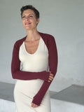 caraucci-woman-wearing-maroon-sleeve-shrug-layered-over-cream-dress-with-thumbhole-detail #color_wine